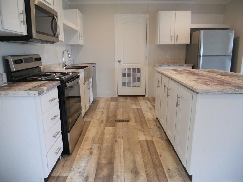 57 Highland Tree Court Ranger, GA 30734 - Photo 24 of 39 a kitchen with a sink a stove top oven and wooden floor