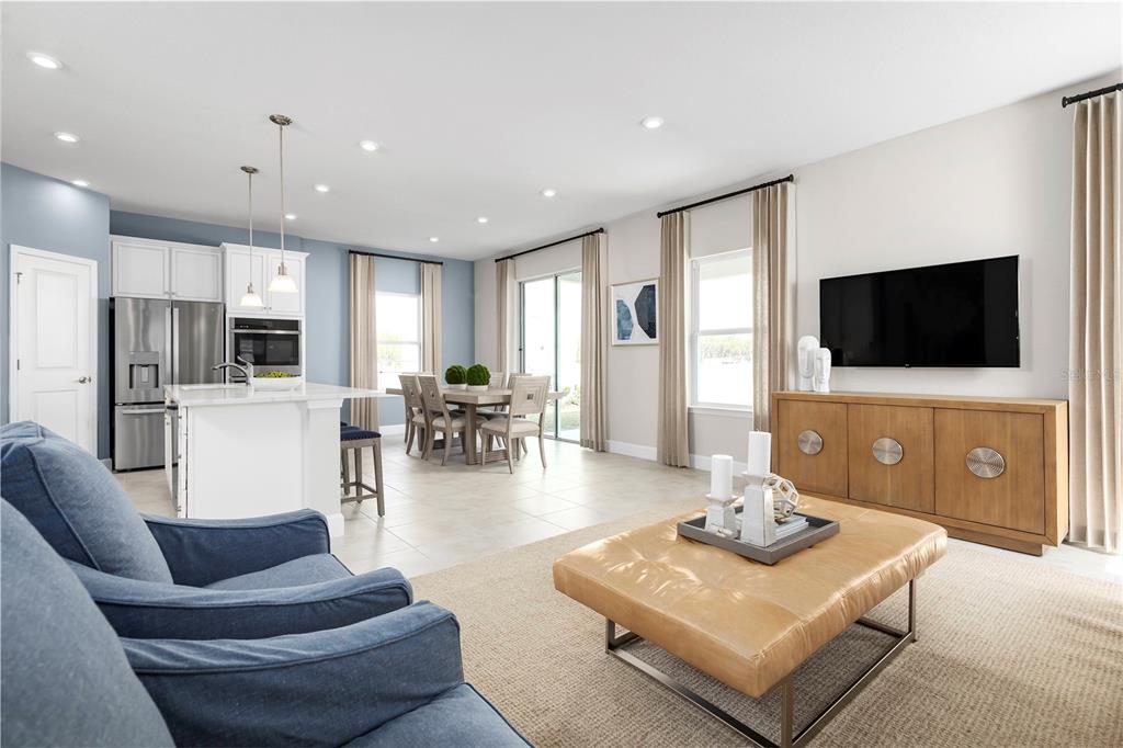 2518 White Ladyfish Road Wimauma, FL 33598 - Photo 5 of 21 a living room with furniture a flat screen tv and kitchen view