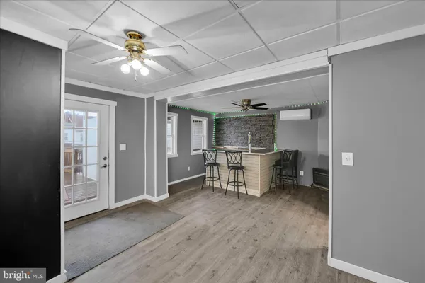 a kitchen with stainless steel appliances granite countertop a refrigerator a sink dishwasher and white cabinets with wooden floor