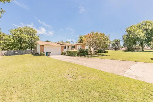 a front view of a house with a yard and lake view