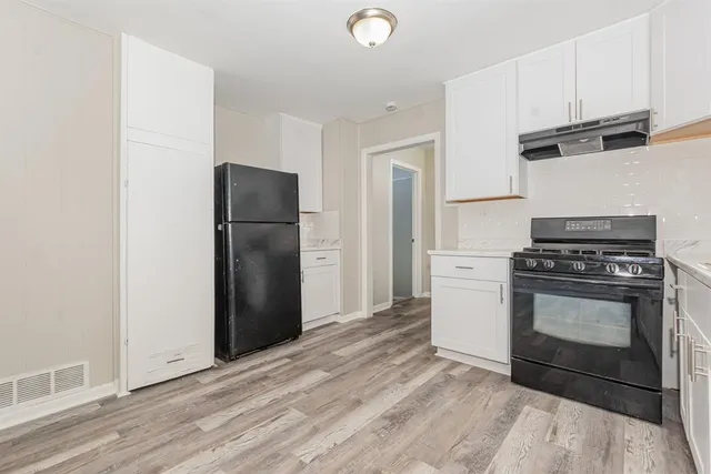 a kitchen with a refrigerator stove and cabinets