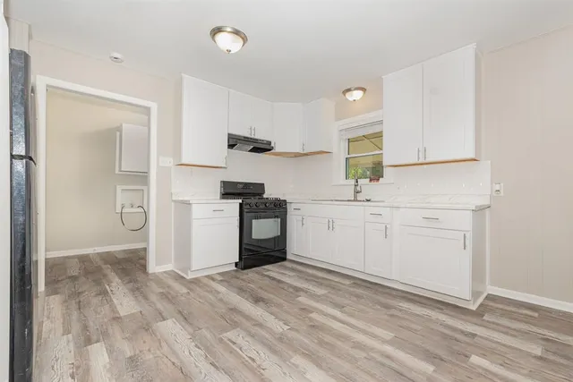 a kitchen with white cabinets and white appliances