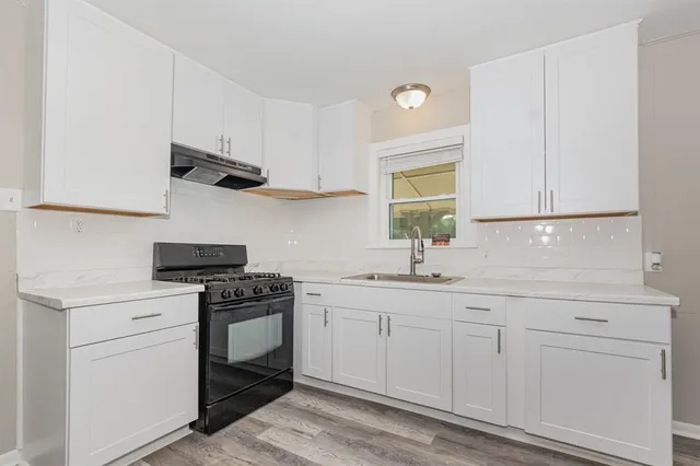 a kitchen with white cabinets and appliances