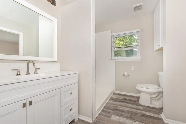 a bathroom with a sink a toilet and a window