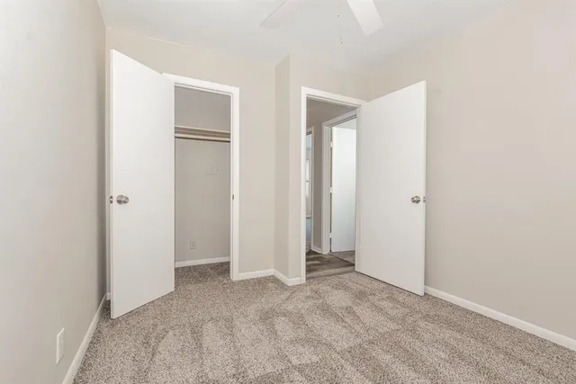 a view of an empty room with closet and a window