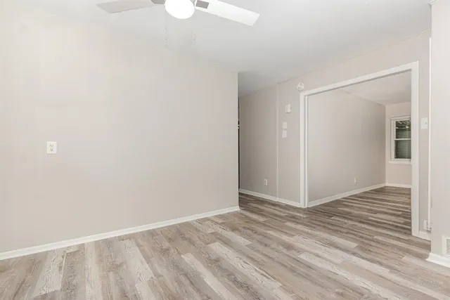 a view of an empty room with wooden floor