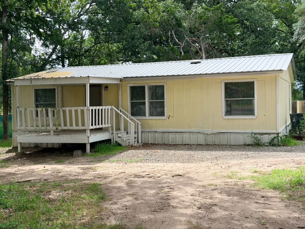 8607 Burleson Manor Road, Unit A Manor, TX 78653 - Photo 2 of 13 A quaint yellow single-story residence is nestled among mature trees.