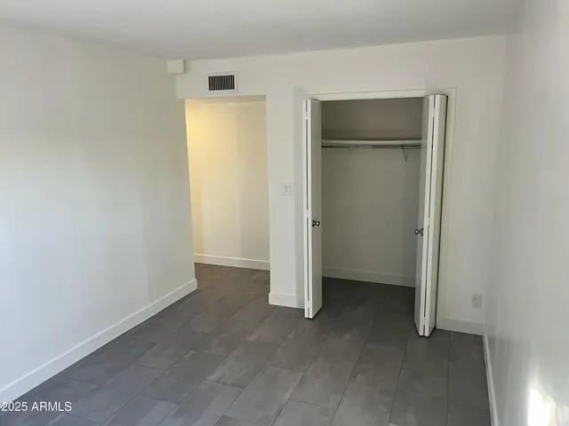 an empty room with wooden floor and mirror