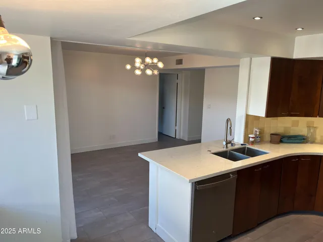 a kitchen with stainless steel appliances wooden cabinets sink and refrigerator