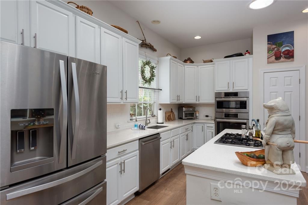8804 Brentfield Road Huntersville, NC 28078 - Photo 16 of 39 a kitchen with refrigerator a stove and cabinets