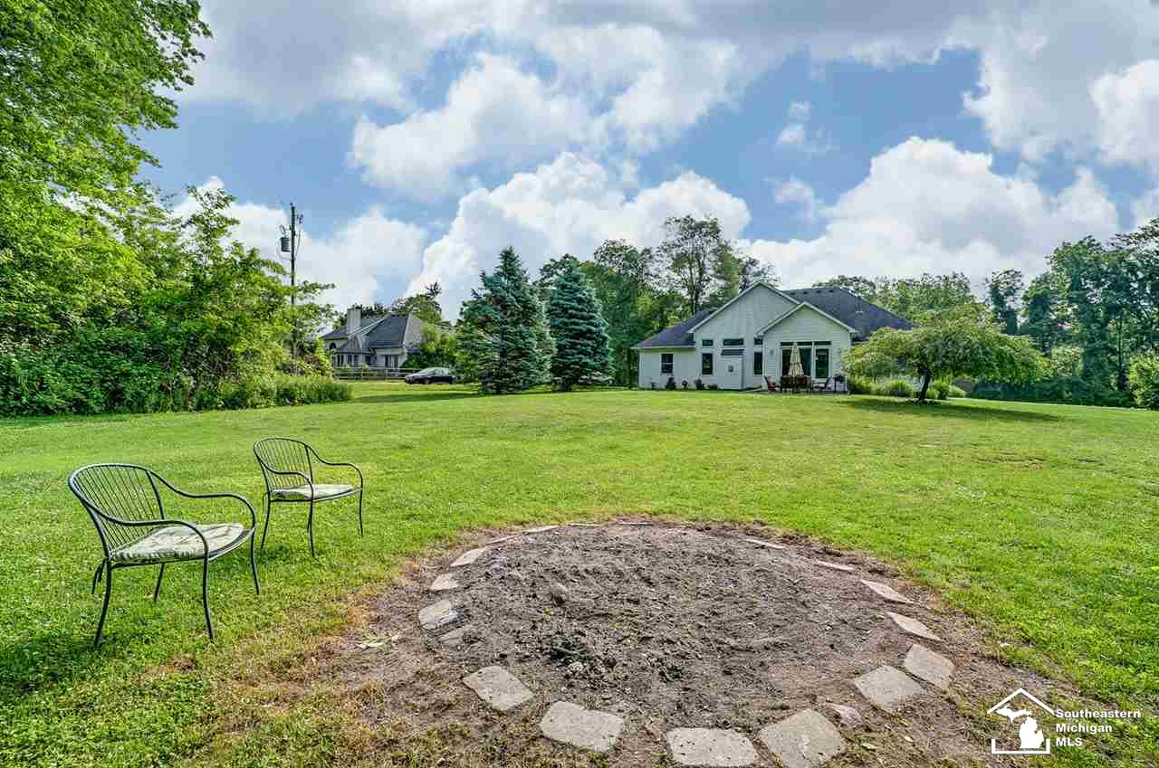 6475 Douglas Road Lambertville, MI 48144 - Photo 38 of 39 Located on 1.75 acres, this large backyard has a firepit and is bordered along property line by trees.