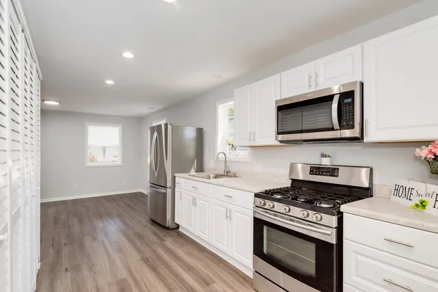 a kitchen with stainless steel appliances a stove microwave and sink
