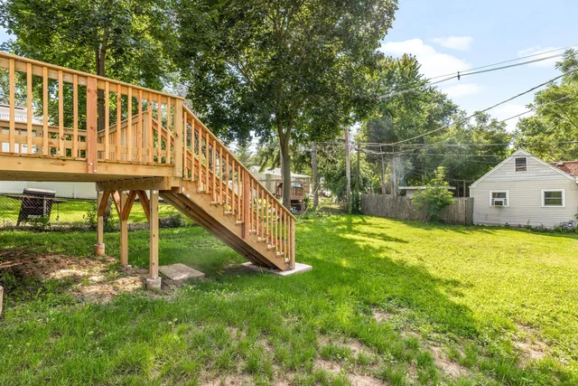 a view of house with backyard and trees