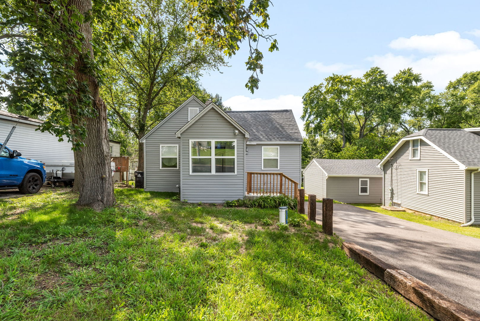 3821 East Wonder Lake Road Wonder Lake, IL 60097 - Photo 2 of 28 a view of a house with a big yard potted plants and large tree