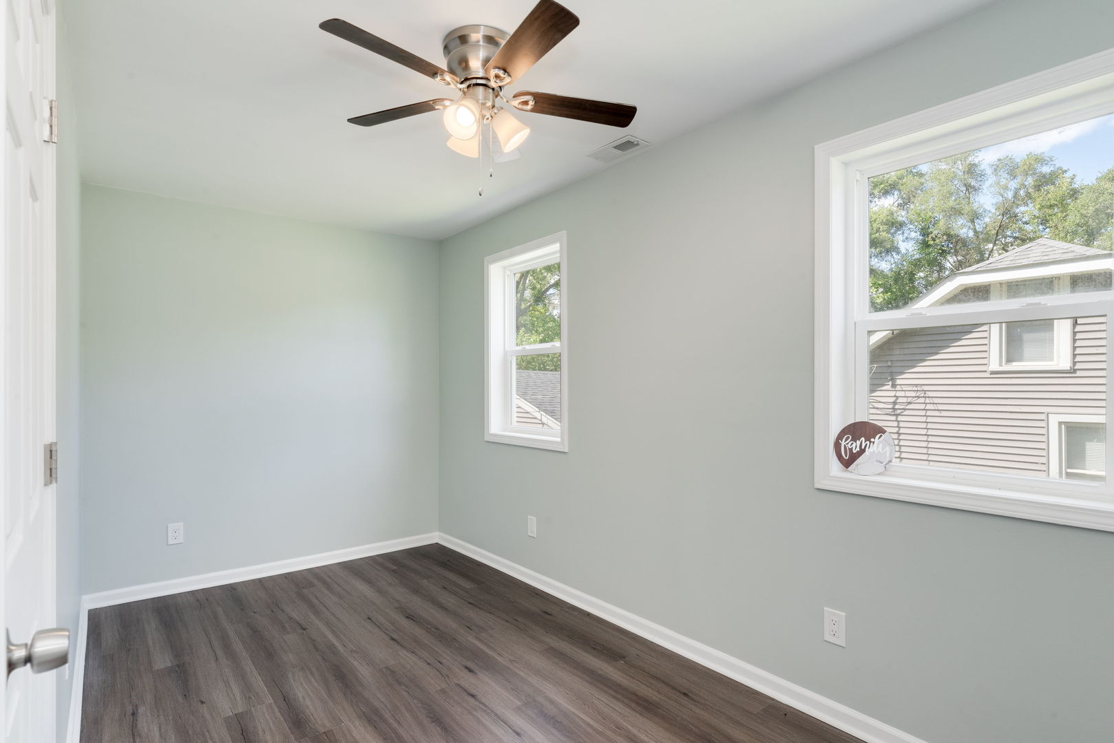 3821 East Wonder Lake Road Wonder Lake, IL 60097 - Photo 4 of 28 an empty room with wooden floor fan and windows
