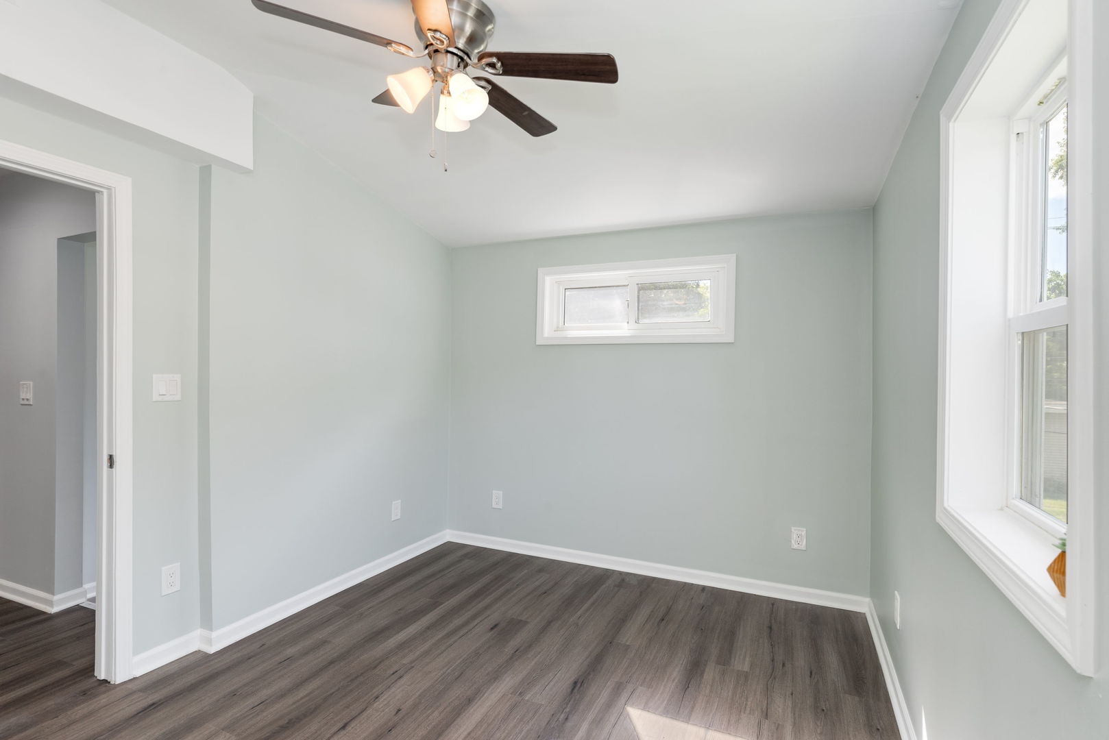 3821 East Wonder Lake Road Wonder Lake, IL 60097 - Photo 10 of 28 an empty room with wooden floor fan and windows