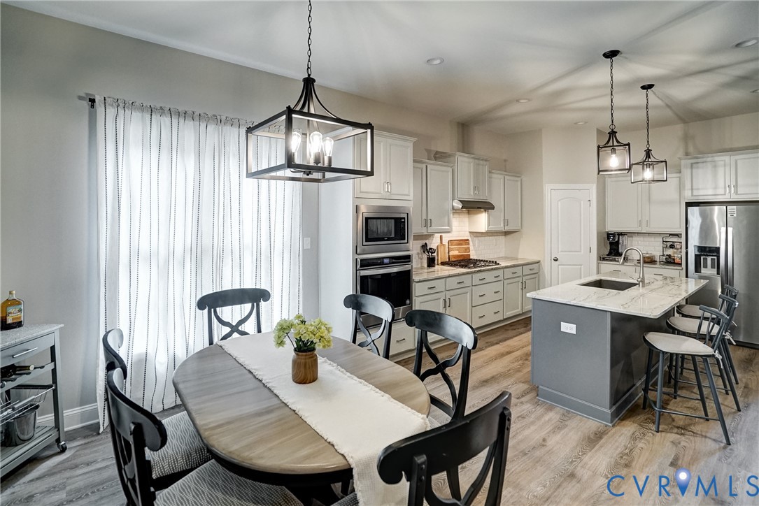 4669 Woburn Road Providence Forge, VA 23140 - Photo 12 of 78 a kitchen with stainless steel appliances granite countertop a dining table chairs stove refrigerator and microwave