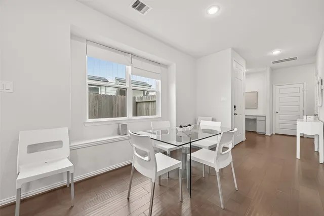 a kitchen with stainless steel appliances granite countertop a sink stove refrigerator and white cabinets with wooden floor