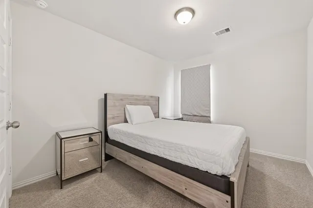 a bedroom with a bed and a lamp