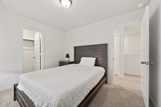 a bedroom with a bed and a night stand