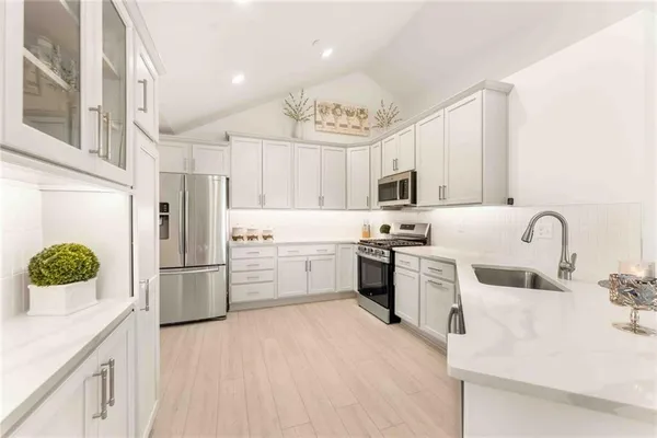 a kitchen with white cabinets and stainless steel appliances