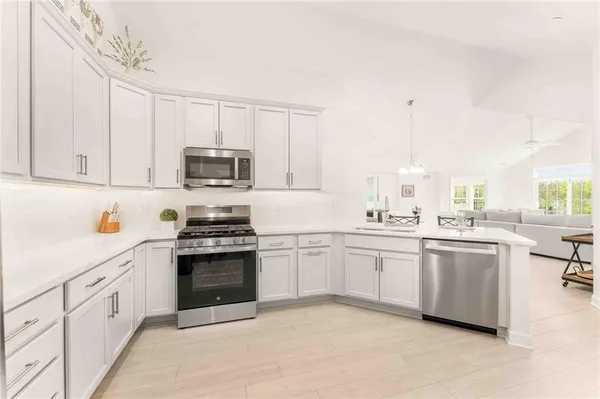 a kitchen with granite countertop white cabinets and white appliances