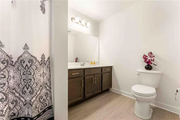 a spacious bathroom with a toilet sink and mirror