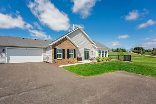 a front view of a house with garage and green space