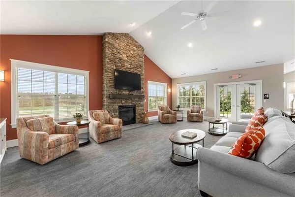 a living room with furniture fireplace and a large window