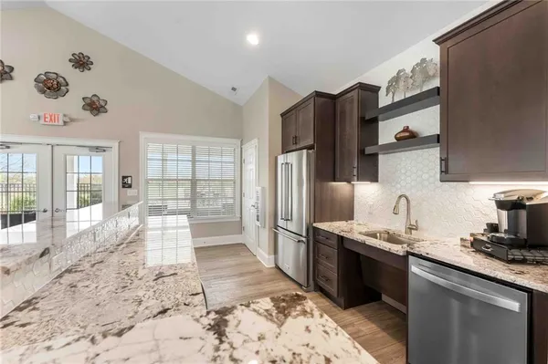 a large kitchen with stainless steel appliances granite countertop a sink stove and refrigerator