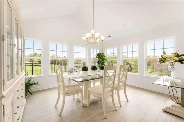 a dining room with furniture a chandelier and wooden floor
