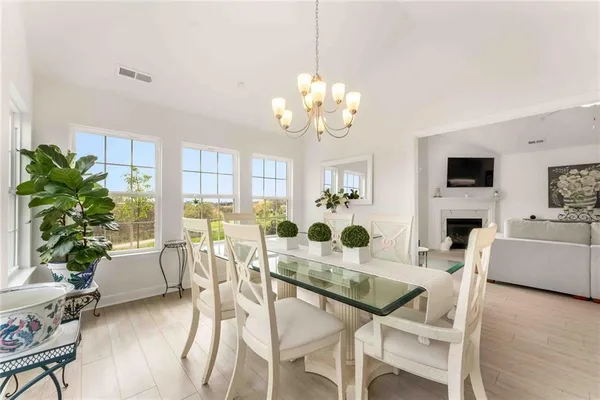 a view of a dining room with furniture a livingroom and chandelier