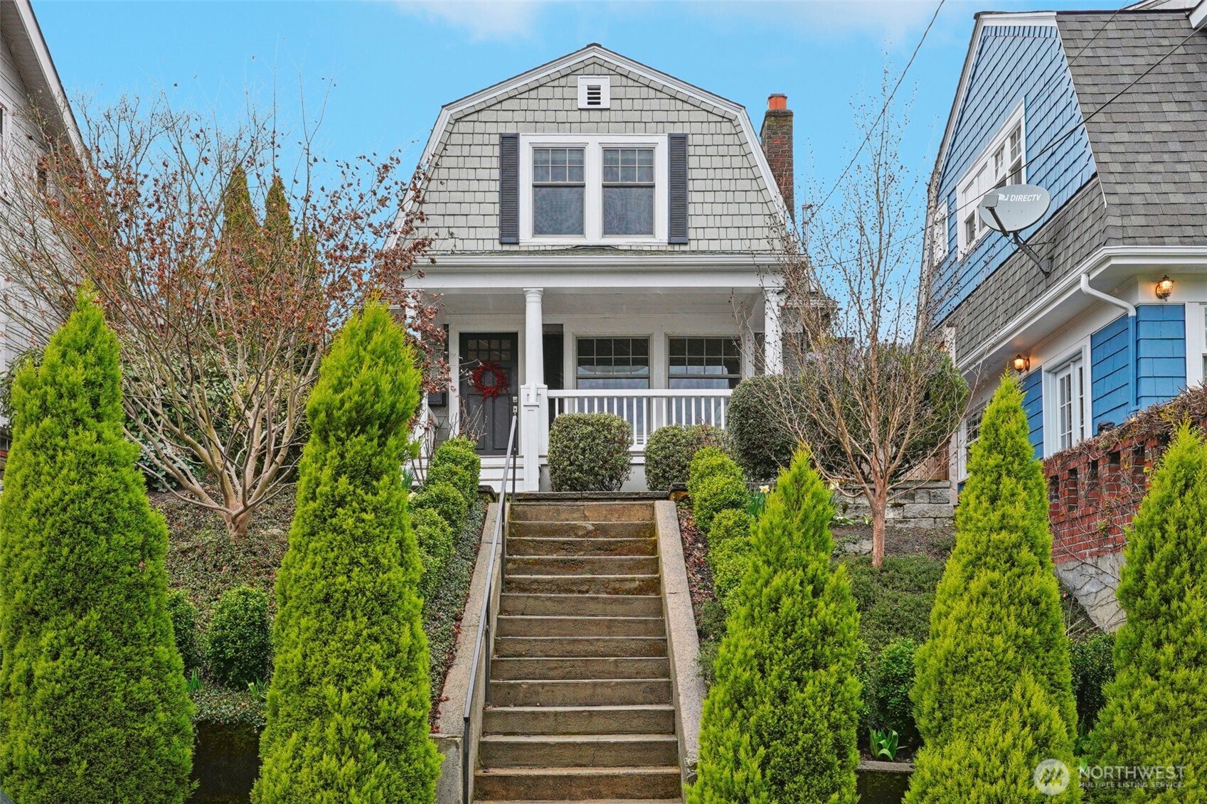 a front view of a house with plants and trees