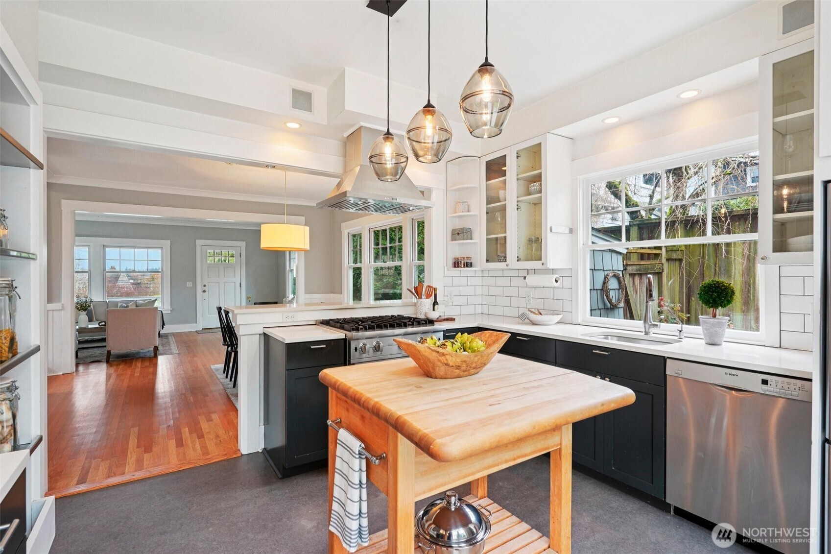 3141 Broadway East Seattle, WA 98102 - Photo 14 of 40 a kitchen with a stove a sink dishwasher a dining table and chairs with wooden floor