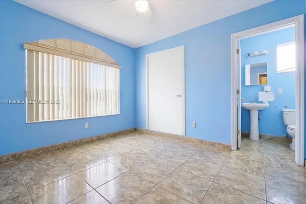 a view of an empty room with window and bathroom