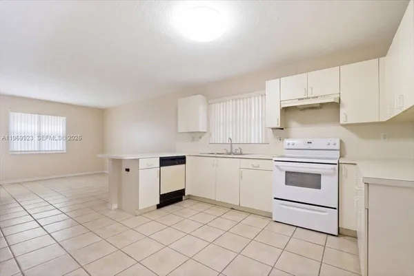 a kitchen with granite countertop white cabinets and white appliances