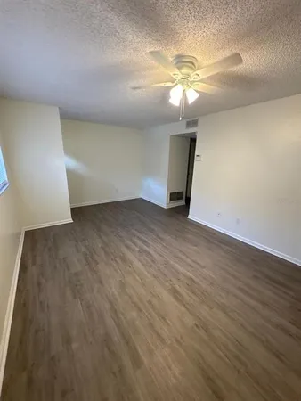 wooden floor in an empty room with a chandelier