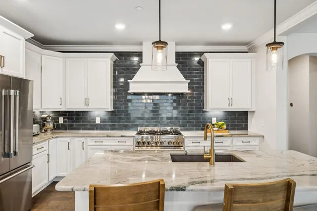 a kitchen with kitchen island granite countertop a table and chairs in it