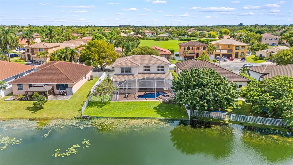 an aerial view of a house with a garden and lake view