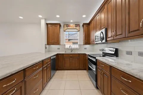 a kitchen with stainless steel appliances granite countertop wooden cabinets a sink and dishwasher