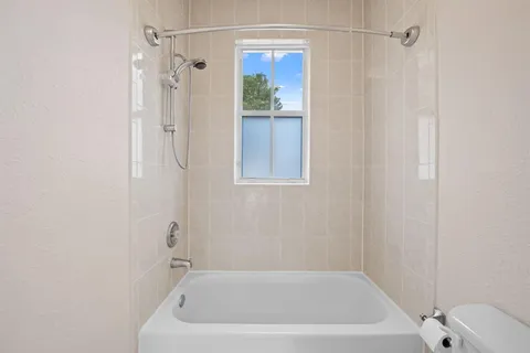 a white bath tub sitting next to a white sink and vanity