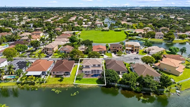 an aerial view of residential houses with outdoor space and lake view