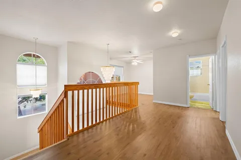 a view of a hallway view with wooden floor and staircase