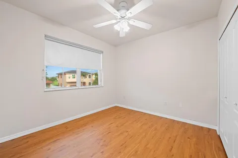 an empty room with a window and a ceiling fan