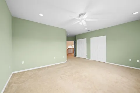an empty room with a ceiling fan and window