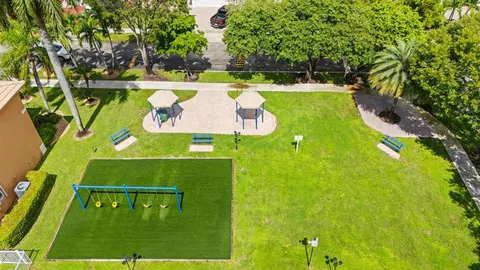 a view of a tennis ground with a large trees
