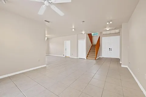 an empty room with a ceiling fan and entryway