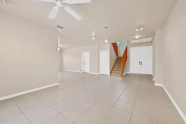 an empty room with a ceiling fan and entryway
