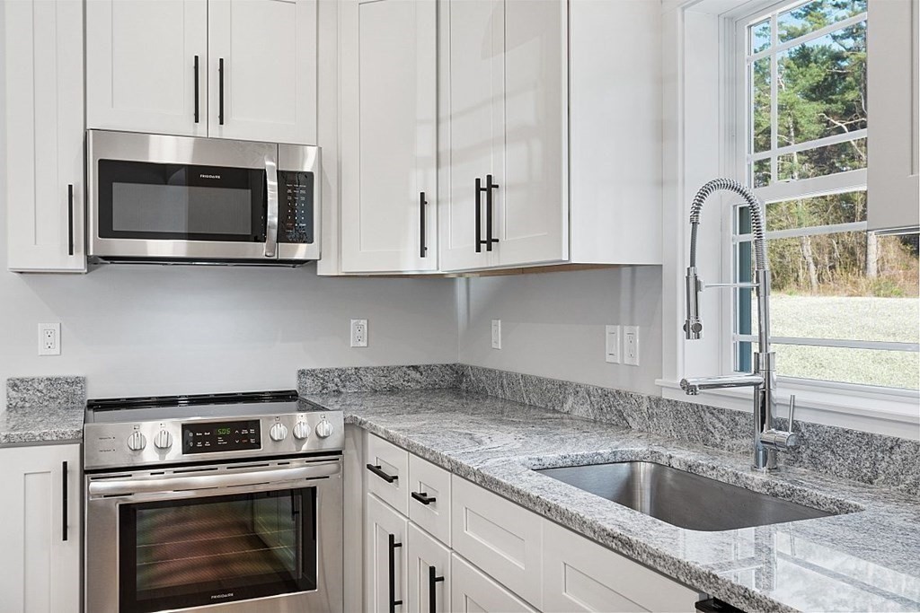 245 Brookside Road Orange, MA 01364 - Photo 7 of 29 a kitchen with granite countertop white cabinets stainless steel appliances and a sink
