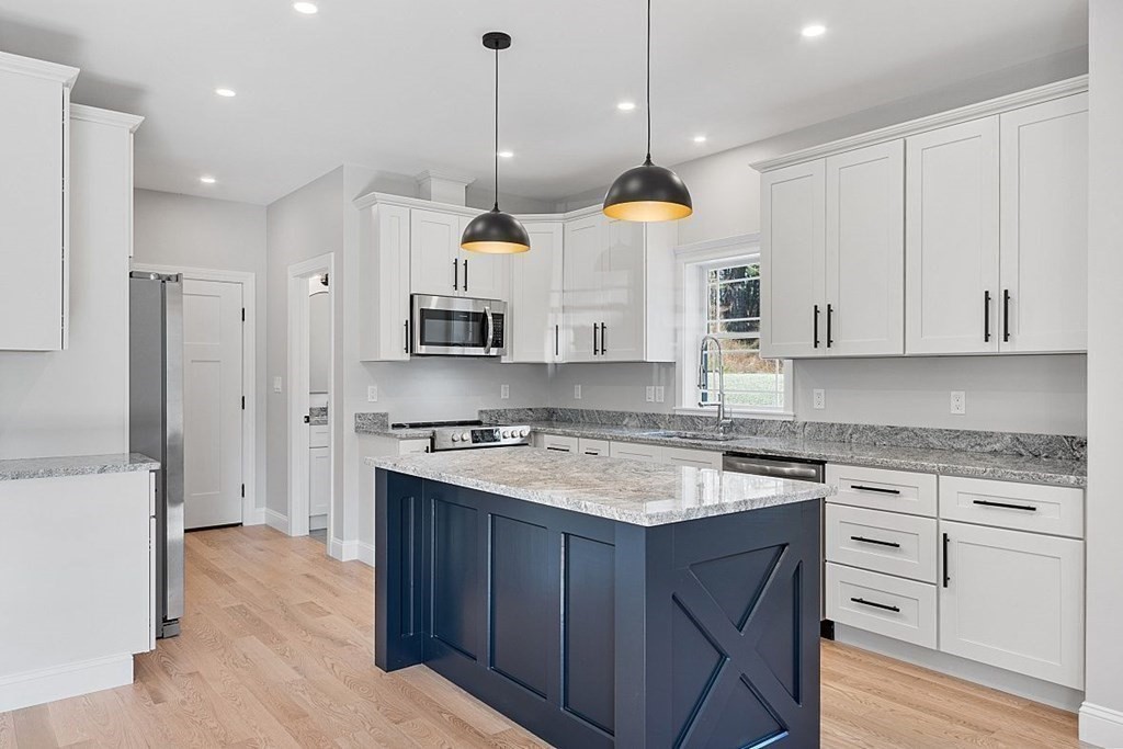 245 Brookside Road Orange, MA 01364 - Photo 10 of 29 a kitchen with stainless steel appliances granite countertop a sink a stove a refrigerator and white cabinets with wooden floor
